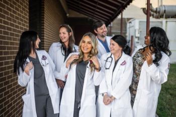 Nursing students wearing white coats and stethoscopes. 